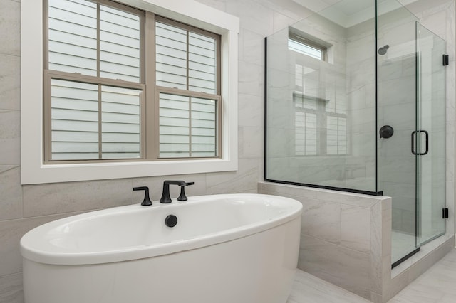 bathroom featuring tile walls, ornamental molding, and independent shower and bath