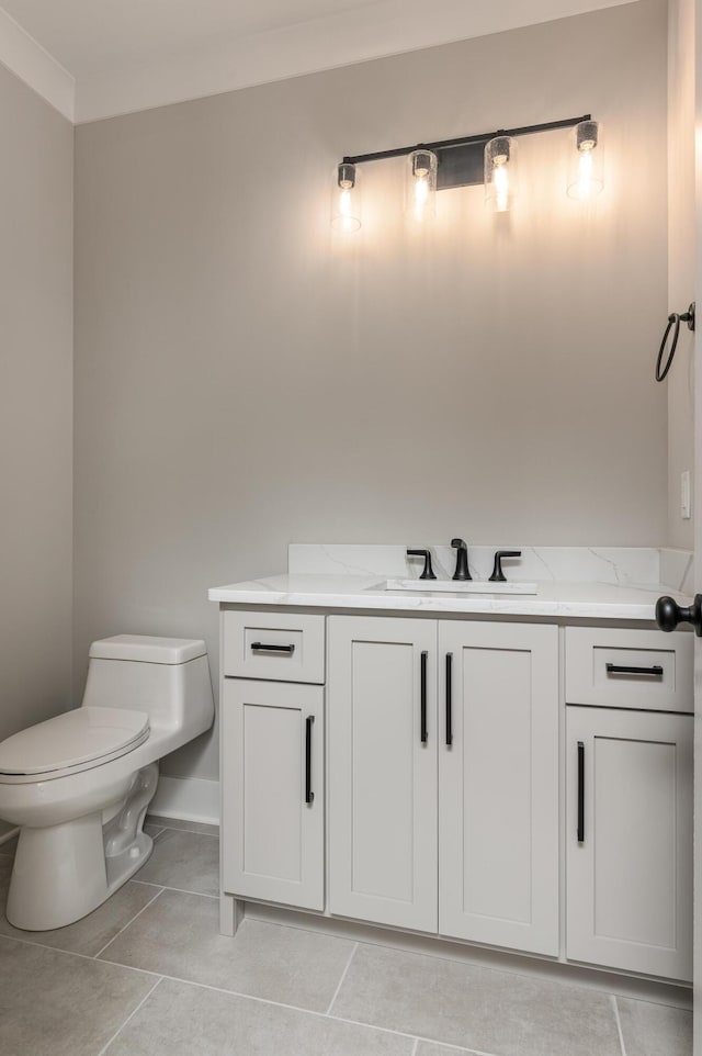 half bathroom with tile patterned floors, toilet, vanity, and baseboards