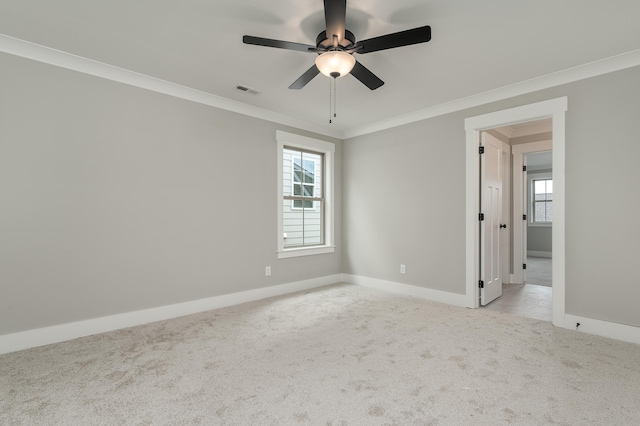 empty room featuring crown molding, ceiling fan, and light carpet