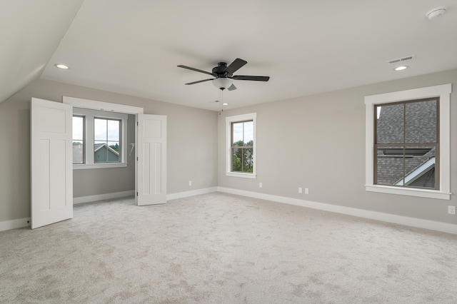 interior space with ceiling fan, light carpet, and vaulted ceiling