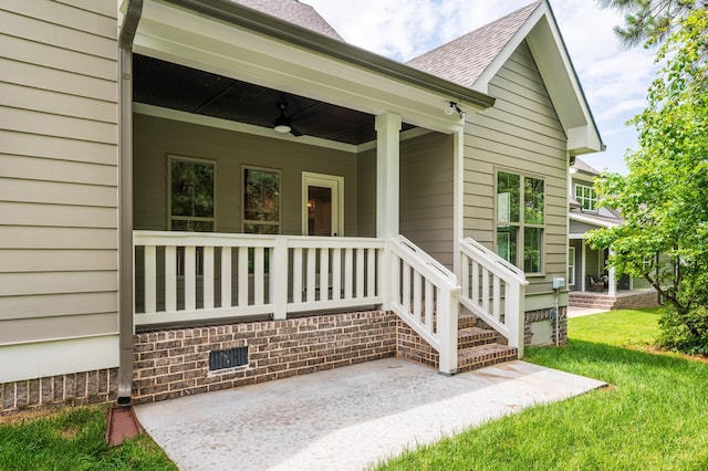 view of exterior entry with a yard, a porch, and ceiling fan