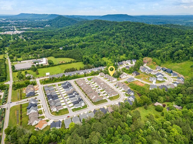 aerial view featuring a mountain view, a wooded view, and a residential view