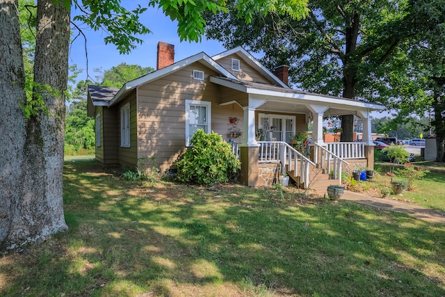 bungalow-style house with a porch and a front lawn