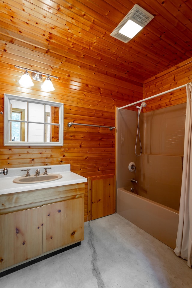 bathroom with shower / bath combination with curtain, wooden walls, concrete floors, and vanity