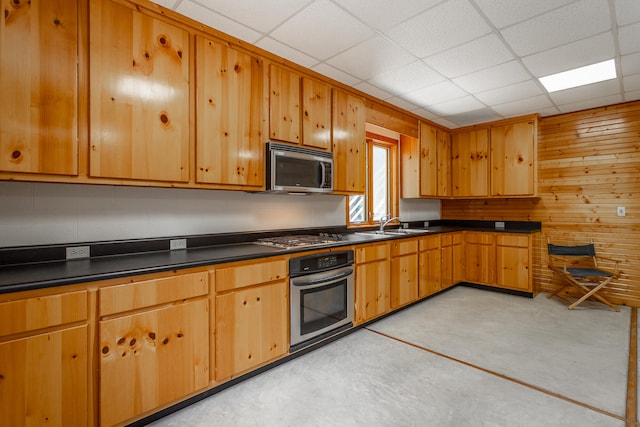 kitchen with a paneled ceiling, stainless steel appliances, and sink