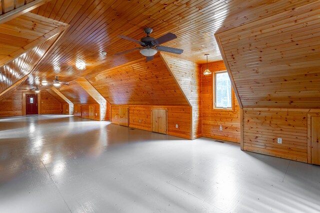 bonus room featuring lofted ceiling, wood walls, ceiling fan, and wooden ceiling