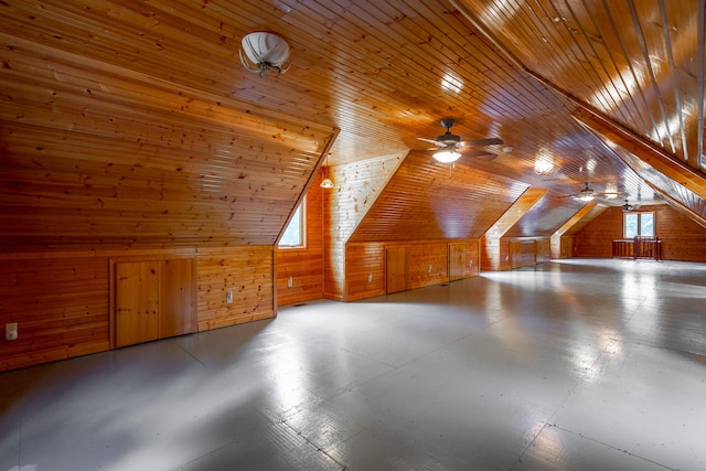 bonus room with wood ceiling, ceiling fan, wood walls, and lofted ceiling