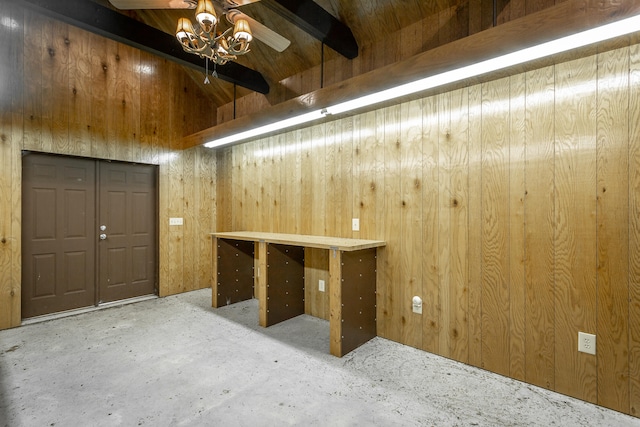 interior space with ceiling fan and wooden walls