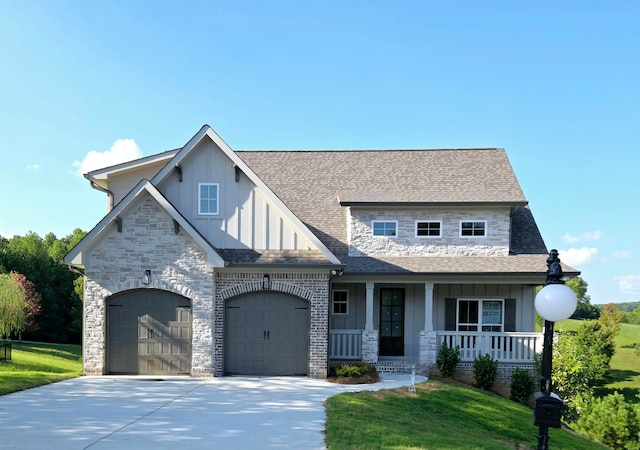 view of front of house featuring a front lawn, a garage, and covered porch