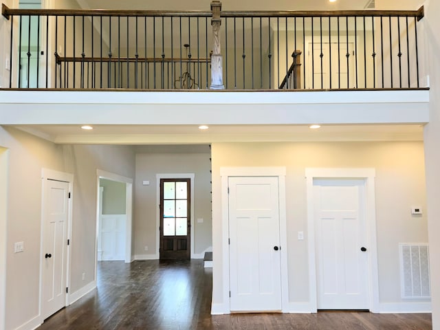 interior space with wood-type flooring and a towering ceiling