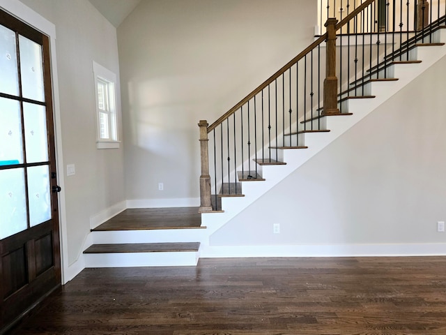 entryway featuring lofted ceiling and dark wood-type flooring