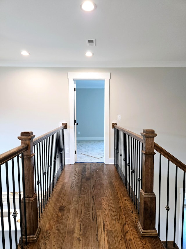 corridor with hardwood / wood-style floors and ornamental molding