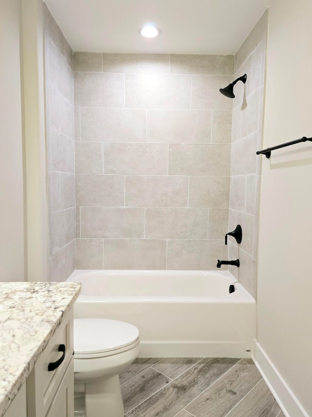 full bathroom featuring tiled shower / bath, toilet, and hardwood / wood-style floors