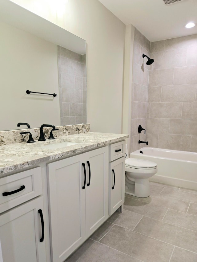 full bathroom featuring tile patterned floors, toilet, tiled shower / bath combo, and vanity