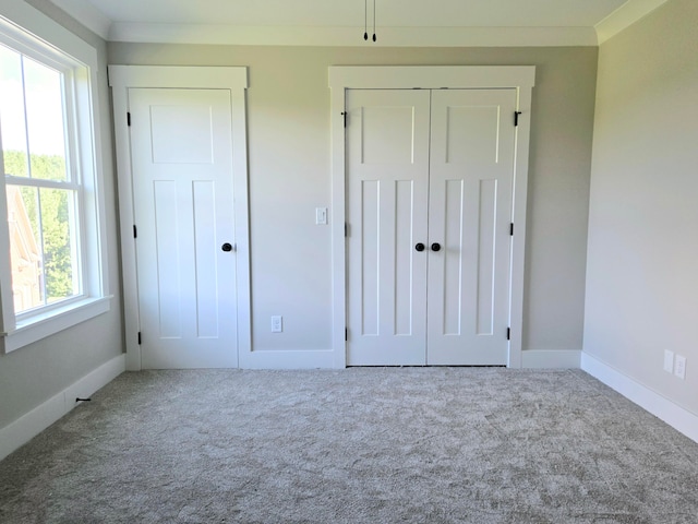 unfurnished bedroom featuring crown molding and carpet floors