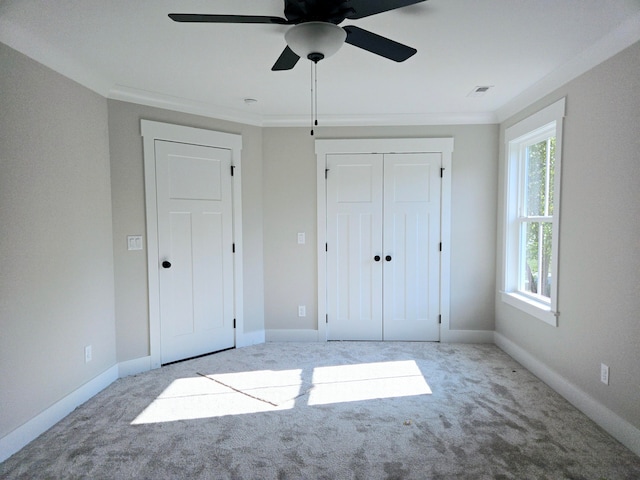 unfurnished bedroom with light colored carpet, ceiling fan, ornamental molding, and a closet