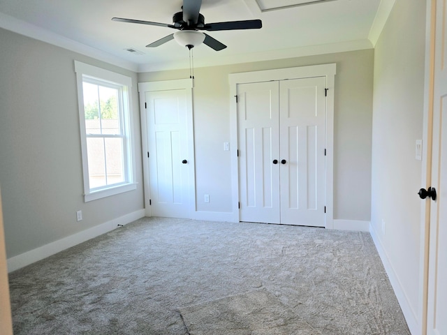 unfurnished bedroom featuring ceiling fan, crown molding, and carpet floors