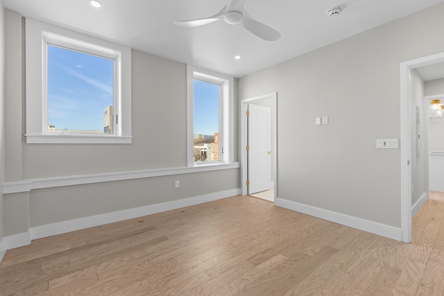 unfurnished room with ceiling fan and light wood-type flooring