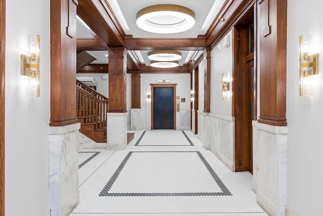 hallway with stairs, ornamental molding, elevator, wainscoting, and ornate columns