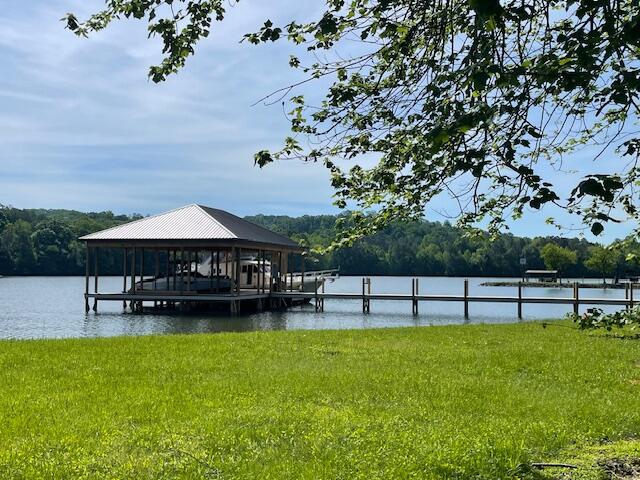 dock area with a water view and a lawn