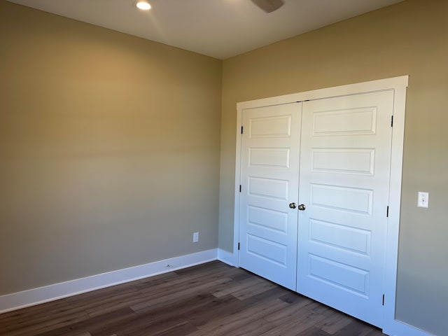 unfurnished bedroom featuring a closet and dark hardwood / wood-style flooring