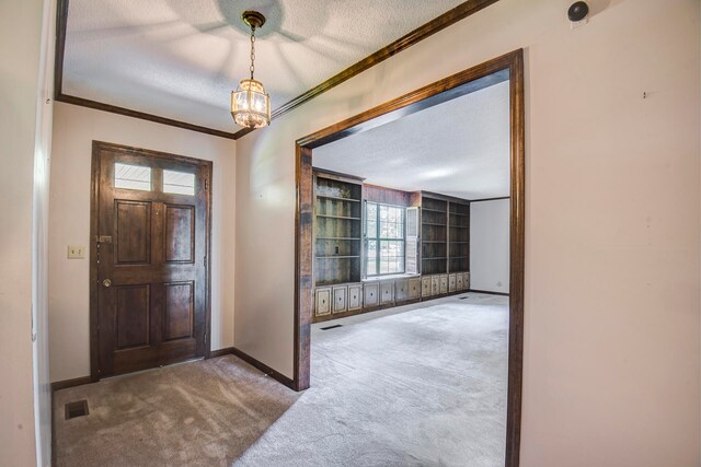 carpeted entrance foyer with crown molding, a textured ceiling, a chandelier, and a wealth of natural light