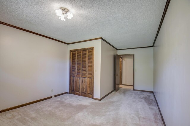 unfurnished bedroom with a closet, light carpet, crown molding, and a textured ceiling