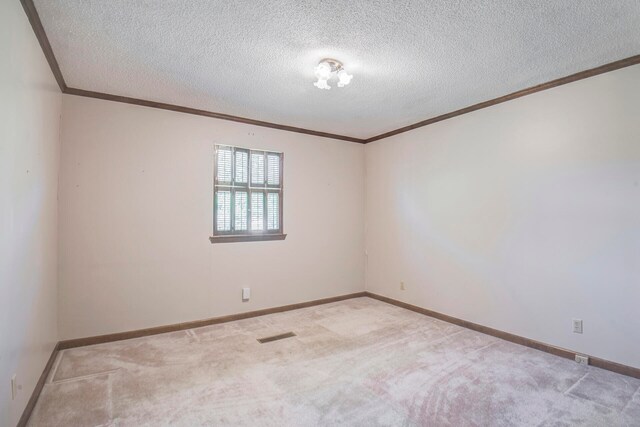 carpeted empty room with a textured ceiling and ornamental molding