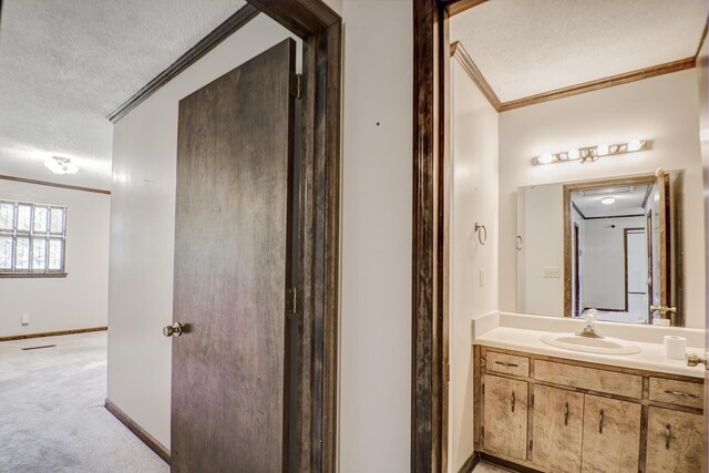 bathroom with vanity, crown molding, and a textured ceiling