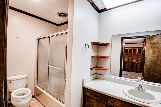 full bathroom featuring combined bath / shower with glass door, a textured ceiling, toilet, vanity, and crown molding