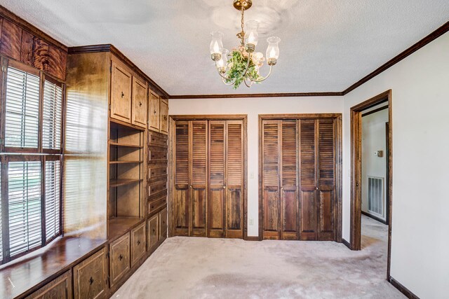 unfurnished office featuring an inviting chandelier, a textured ceiling, light colored carpet, and crown molding