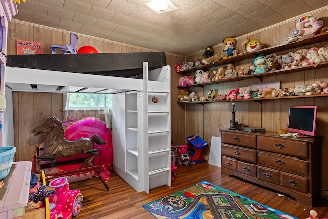 bedroom with wood walls and hardwood / wood-style flooring