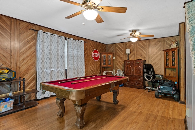 game room with wood-type flooring, pool table, ceiling fan, and wooden walls