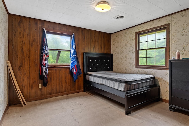 bedroom with multiple windows, wooden walls, and ornamental molding