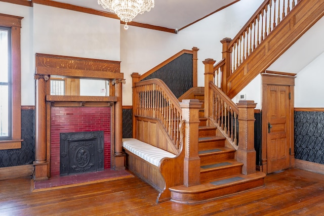 stairs featuring hardwood / wood-style flooring, ornamental molding, and a chandelier