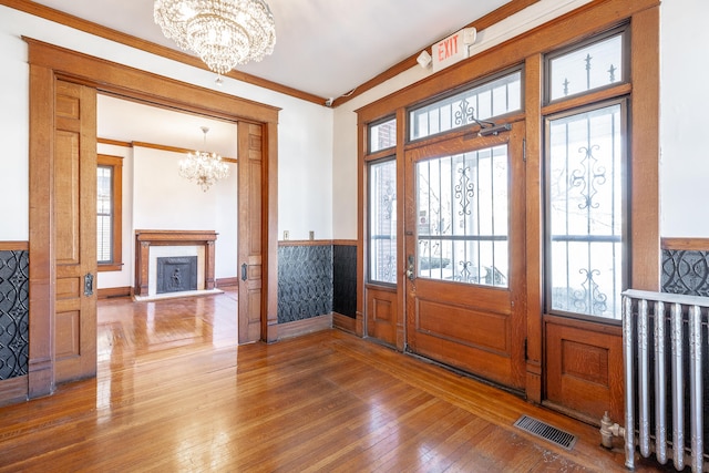 entrance foyer featuring a healthy amount of sunlight, dark hardwood / wood-style flooring, and a chandelier