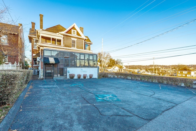 back of property with a sunroom and central air condition unit