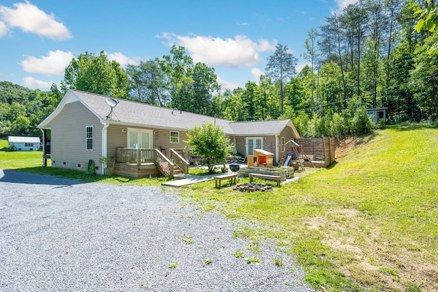 single story home featuring a deck and a front yard