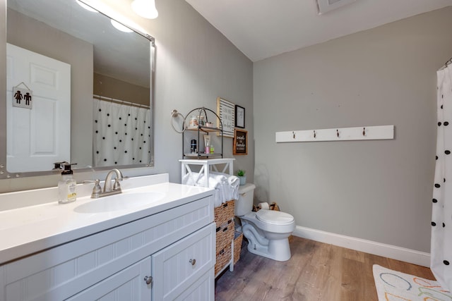 bathroom with toilet, hardwood / wood-style flooring, and vanity