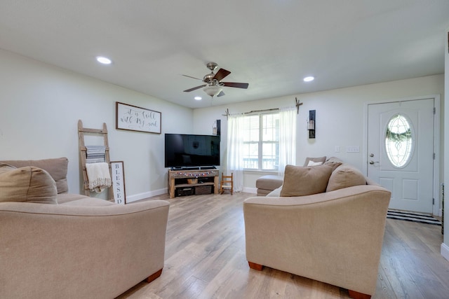 living room featuring ceiling fan and light hardwood / wood-style floors