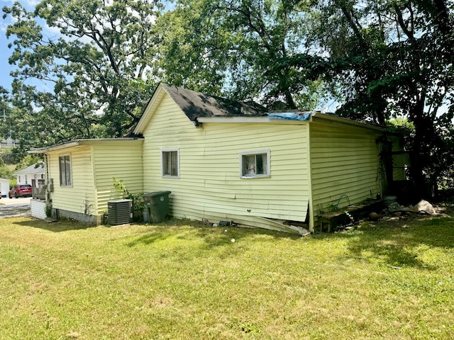 rear view of property with a yard and central AC