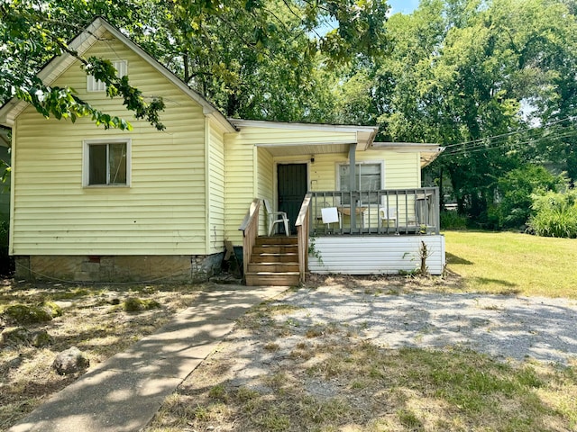 bungalow-style home with a front lawn and a porch