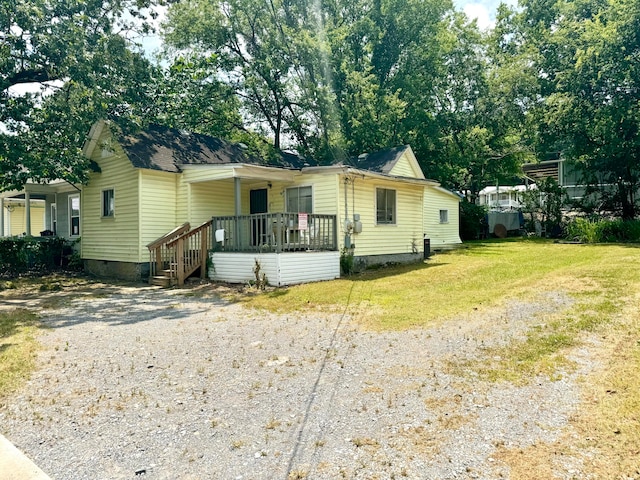 view of front of home with a wooden deck and a front yard