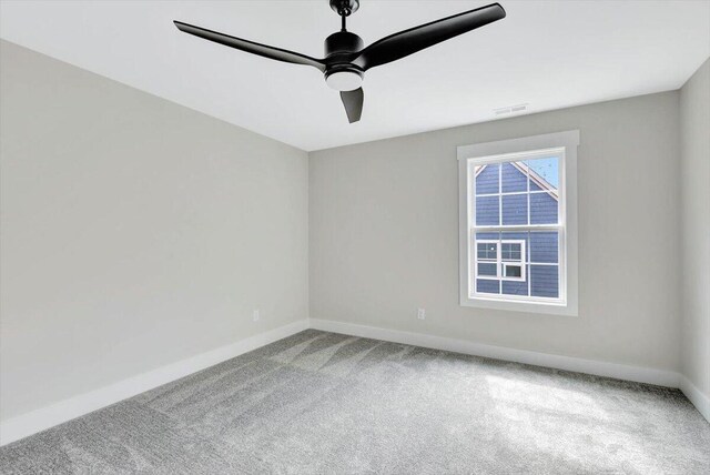 unfurnished room with ceiling fan and carpet