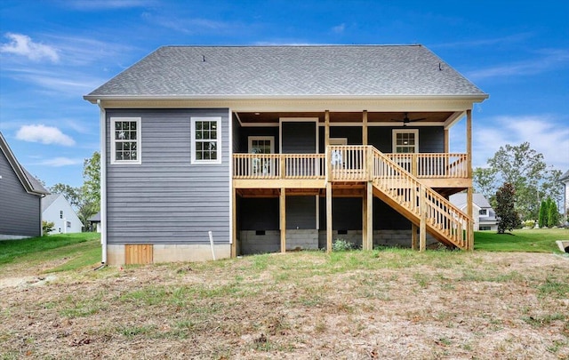 back of house featuring a wooden deck, ceiling fan, and a yard