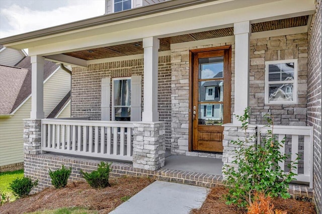 view of exterior entry featuring covered porch