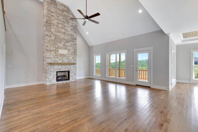 unfurnished living room featuring light hardwood / wood-style floors, high vaulted ceiling, ceiling fan, and a fireplace