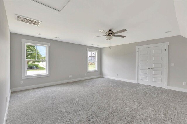 carpeted spare room featuring ceiling fan