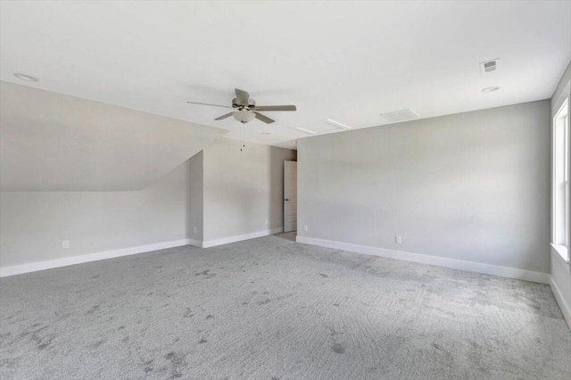 interior space featuring light colored carpet, ceiling fan, and vaulted ceiling