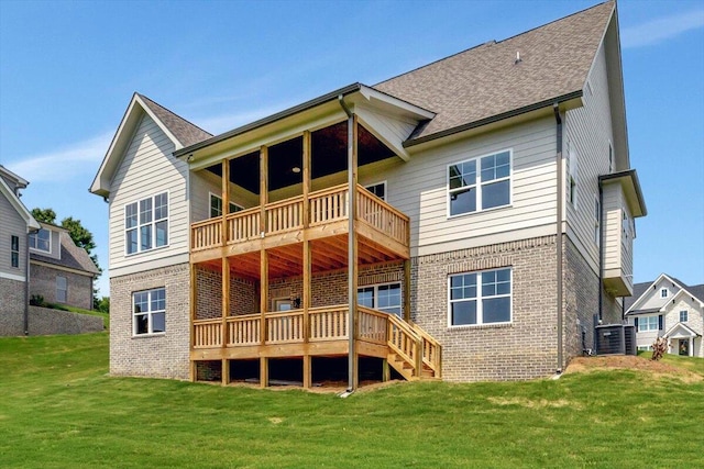 back of property featuring a balcony and a lawn